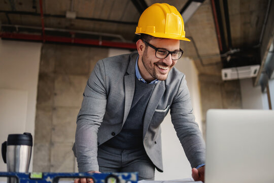 Smiling architect standing at construction site and working on important project.