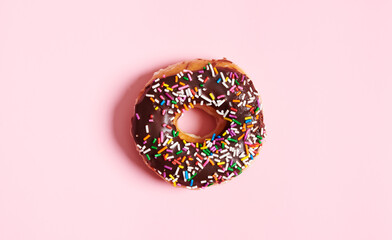One Choclolate Sprinkle Donut on Pink Background