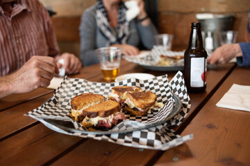Closeup photo of a Reuben sandwich and beer.