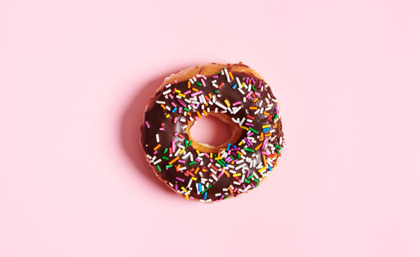 One Choclolate Sprinkle Donut on Pink Background 