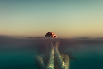 Woman holding her face in the sea