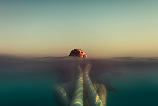 Woman holding her face in the sea