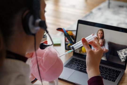 Cop doctor with syringe and toy having video call with patient
