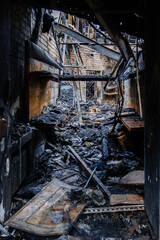 Burnt out shop after fire with charred walls and remains of furniture