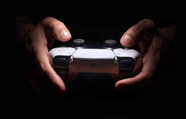 Man holding a game controller in dark room © miglagoa