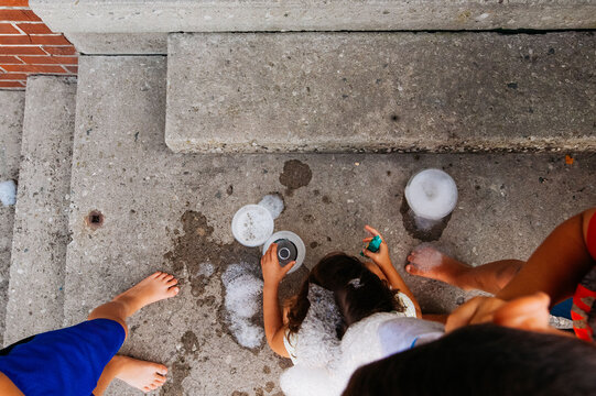 Playing with cups and bubbles on the front porch. 