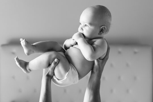 Man Hands Holding A Baby In The Air