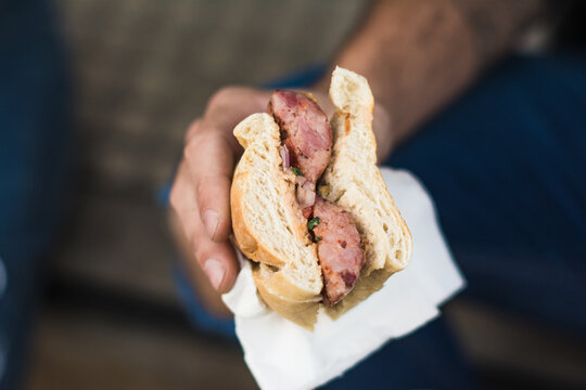 Hand holding a chorizo sandwich