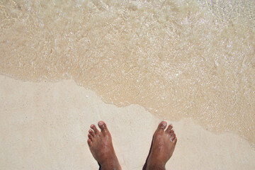 Feet in the sand at the seaside