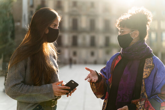 Two young woman using protective face mask during the Covid-19