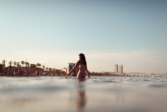 Girl entering into the waters of Barcelona beach