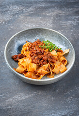 Modern style traditional Italian ragu alla bolognese sauce with papedelle pasta noodles and...