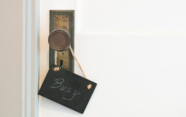 busy sing hanging  on the vintage latch door 