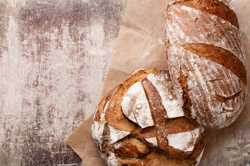 Assortment of baked bread on wooden table background.