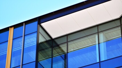 Glass facade of the buildings with a blue sky. Modern building in the business city center. Background of modern glass buildings. 