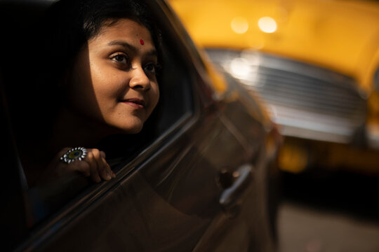 Cute Indian woman inside a car looking outwards