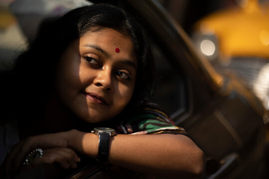 Cute Indian woman inside a car looking outwards