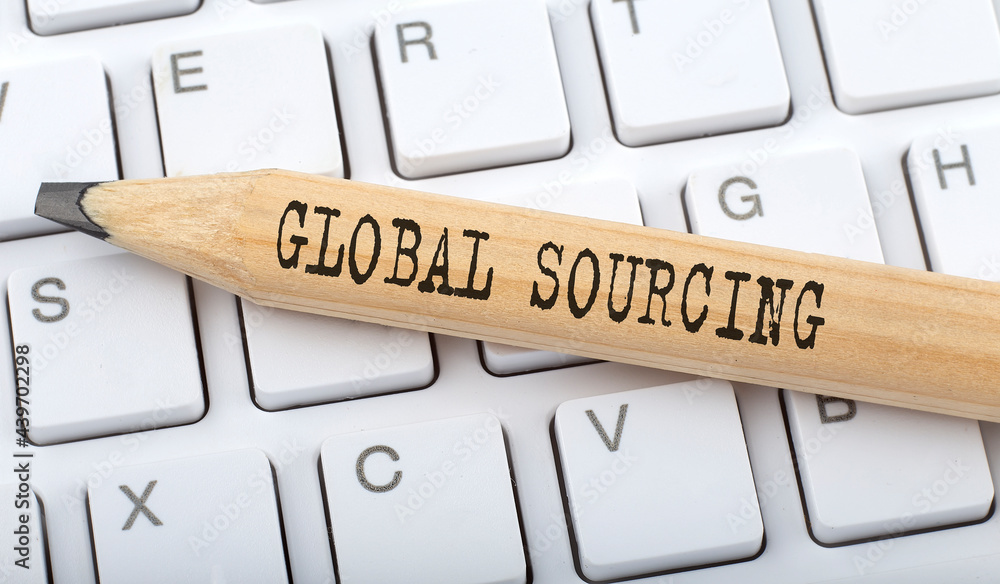 Poster global sourcing text on pencil on the keyboard on background