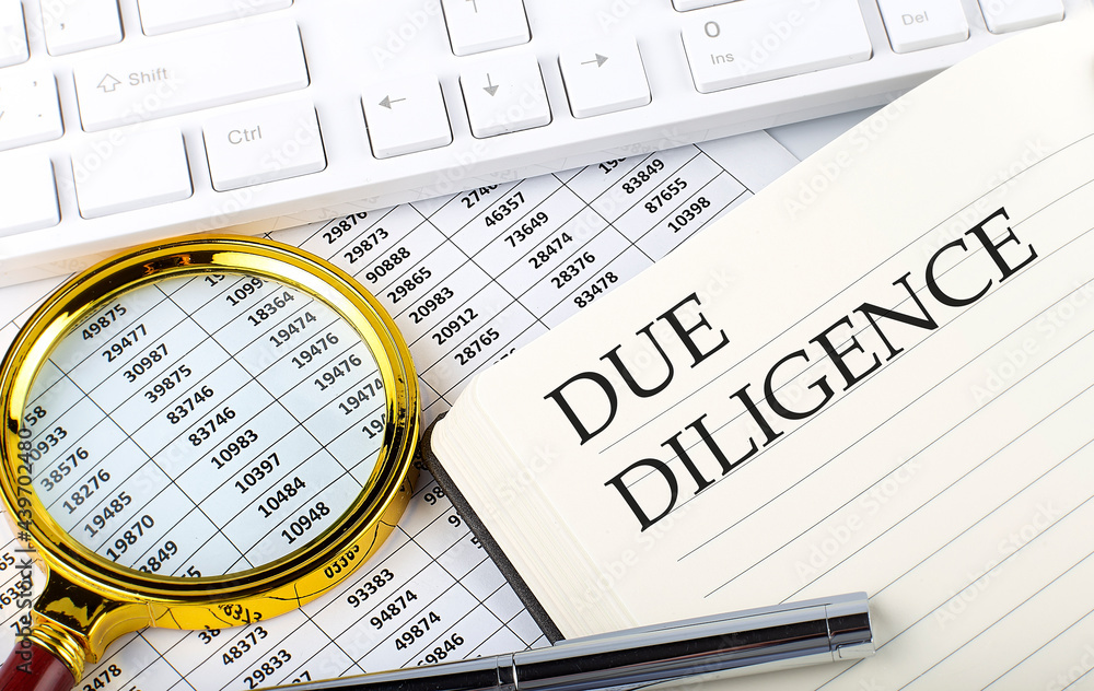 Poster due diligence text on notebook with chart, magnifier,keyboard and pen