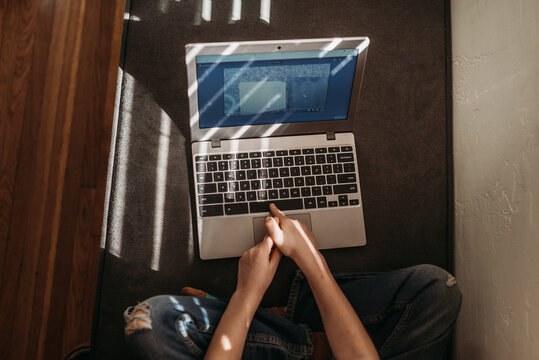 Above view of child's hands and laptop during distance learning