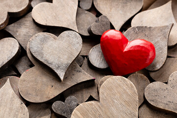 Wooden hearts, one red heart on the heart background..