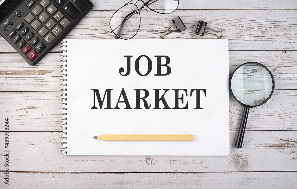 Poster blank notebook with text job market on white background with calculator and office tools.
