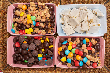 Christmas basket with sweets, chocolate peanuts, colored sprinkles, sugary peanuts and nougats