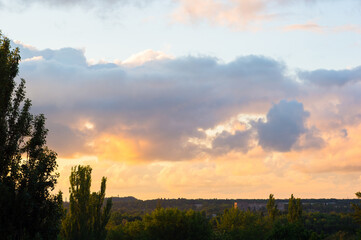 Landscape with dramatic light - beautiful golden sunset with saturated sky and clouds.