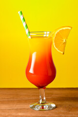 two glass glasses with grenadine cocktail decorated with pepper and mint on a wooden table with ice and peppers next to the glass.
isolated on green background