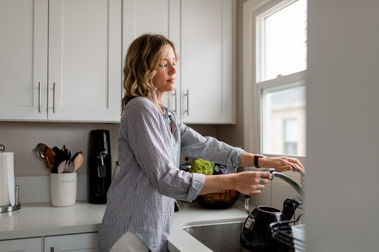 Beautiful Woman Fills Teapot With Water