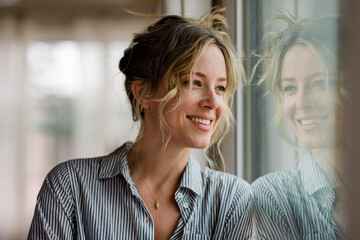 Beautiful Woman Smiles While Looking Out a Window
