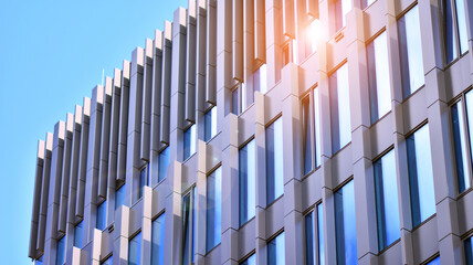 Reflection of modern commercial building on glass with sunlight. Geometric structure glass windows. 