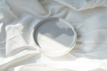 Obraz na płótnie Canvas Empty round tray on white textured linen background, designer jewelry plate