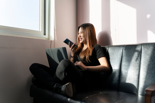 A woman sitting on a sofa using a mobile phone