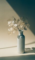 Bouquet of dried lunaria in ceramic vase on beige studio background
