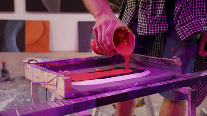 A handsome painter is mixing paints in a pallete