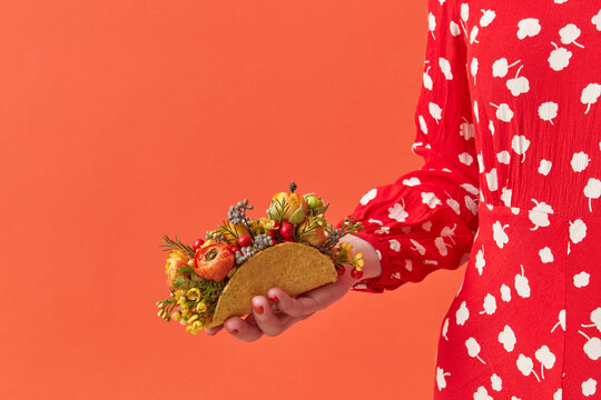 Cropped image of woman holding taco with flowers