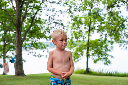 Little boy stading near a lake