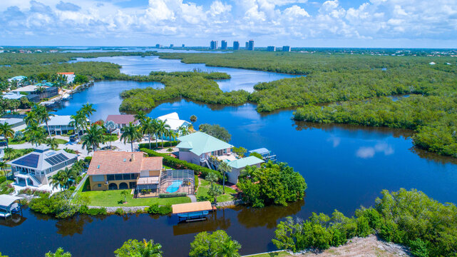 Aerial bay view with homes in Florida and high rises in the background surrounded by blue water