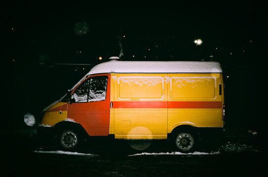 Yellow and red van in a snowy night