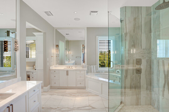 Modern Master Bathroom with Glass Shower Door and a large Soaking Tub in the Corner 