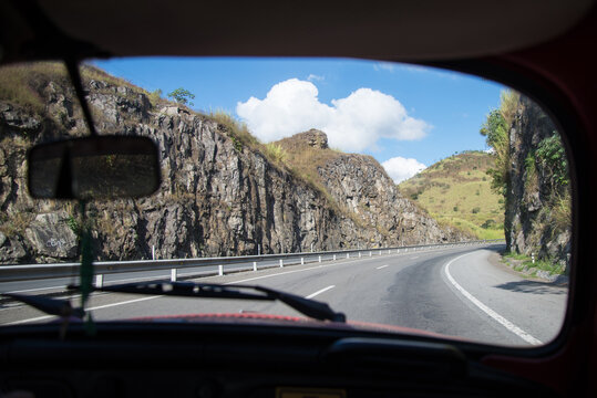 Point of view from the inside a vintage car with a rocks and mountains 