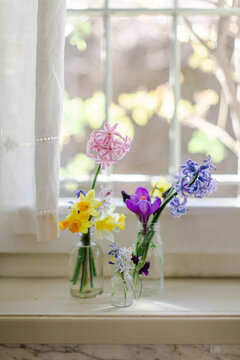 Three vases with flowers on windowsill