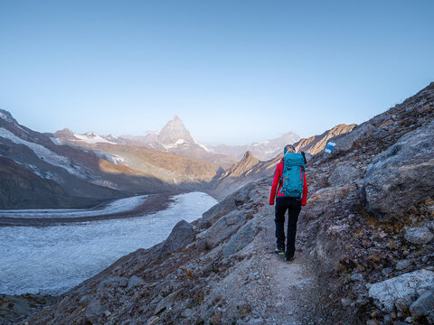 Female backpacker hiking along glacier in Zermatt