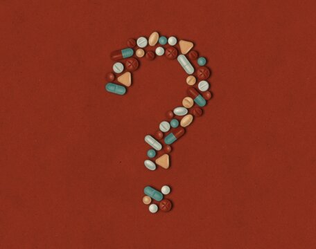 Many multi-colored medicines and pills in the form of a question mark