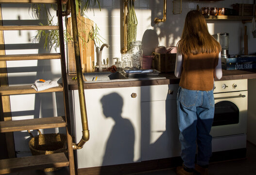 Anonymous teenager cooking in kitchen