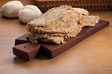 raw milaneses on wooden board