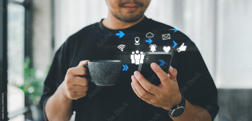 Poster man using smartphone with social web icon popup on the phone in living room at home, man using cellp