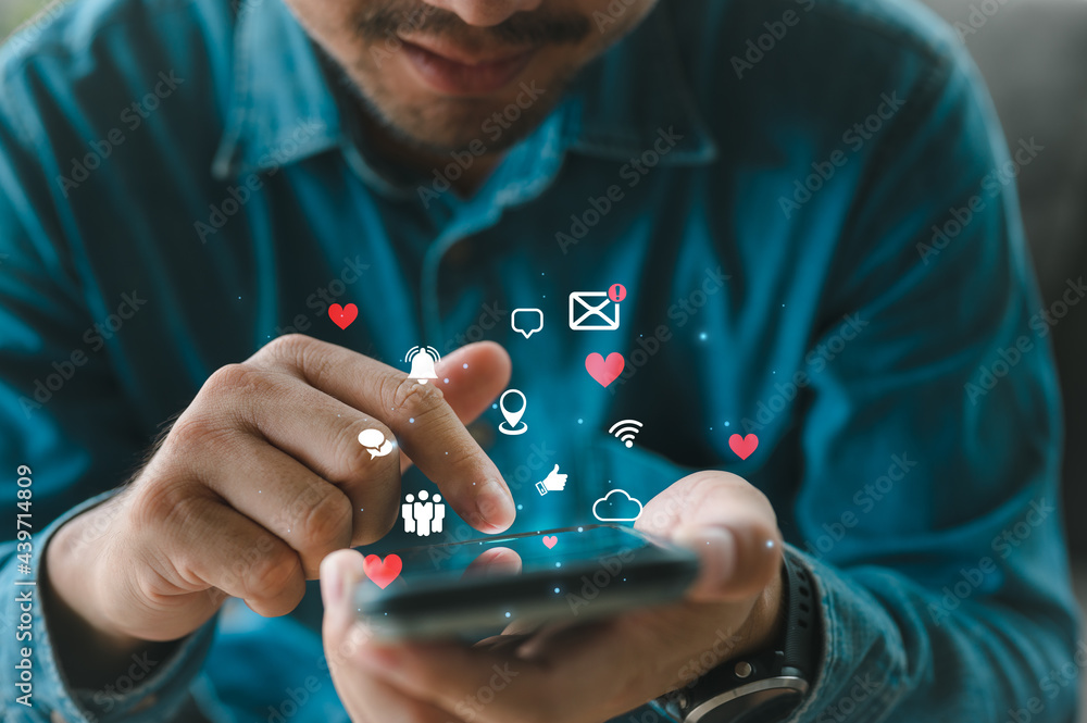Poster man using smartphone with social web icon popup on the phone in living room at home, man using cellp