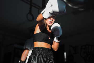 Female Kick-Boxing Athlete Punching On Teardrop Punching Bag